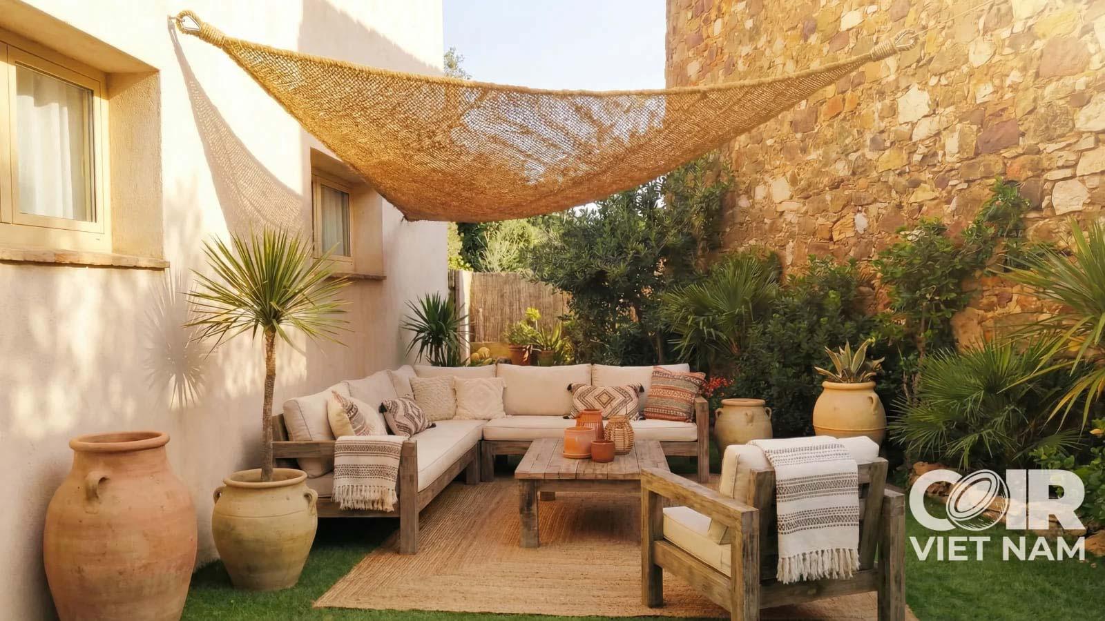 Coir canopy stretched above a cozy outdoor patio lounge with wooden furniture, woven texture, and Mediterranean-style decor.